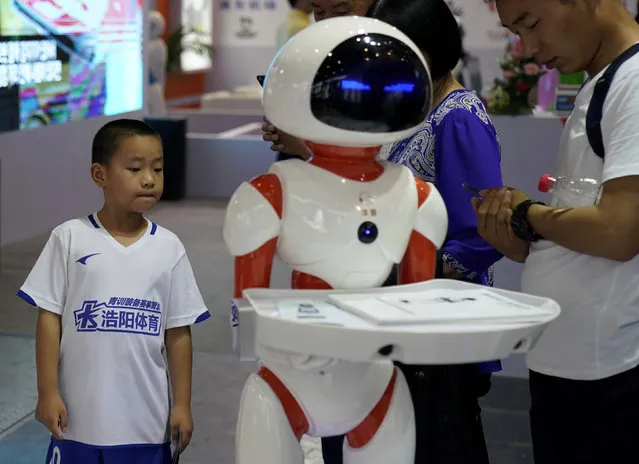 Visitors look at a humanoid robot at 2017 China International Robot Show in Shanghai, China July 5, 2017. (Photo by Aly Song/Reuters)