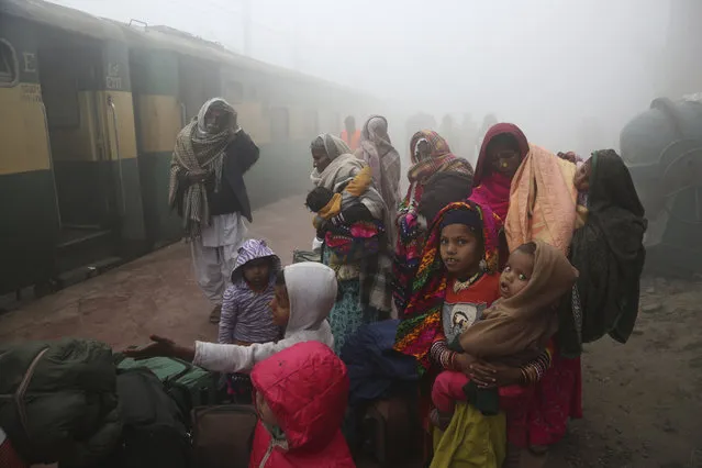 People wait for a train at Lahore station during a foggy morning in Pakistan, Friday, January 17, 2020. People of Lahore and adjacent area are suffering from respiratory problems because of poor air quality related to thick smog hanging over the region. (Photo by K.M. Chaudary/AP Photo)