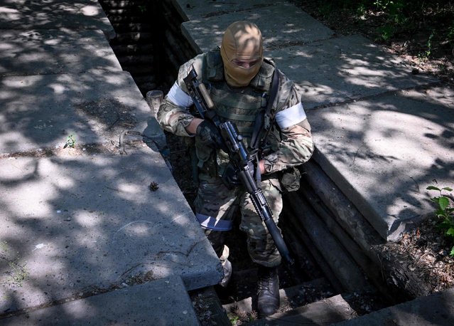 A Russian serviceman patrols the captured piont of defence of the Ukrainian army outside the town of Schast'ye on June 11, 2022, amid the ongoing Russian military action in Ukraine. (Photo by Yuri Kadobnov/AFP Photo)