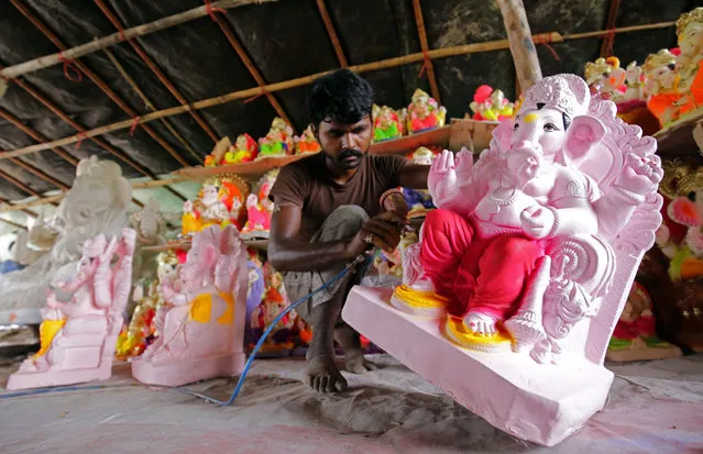 An Indian artist paints an idol of Hindu elephant-headed god Ganesha to prepare for the forthcoming Ganesha Chaturthi festival at a roadside workshop in Amritsar, India, 21 July 2017. The Ganesha Chaturthi is one of the biggest Hindu festivals which is celebrated in honor of the god Ganesha for ten days throughout India. During the festival, idols of Ganesha are installed and worshiped in temporary public shrines as well as at home before they are immersed in water bodies after a gala street procession. (Photo by Raminder Pal Singh/EPA)