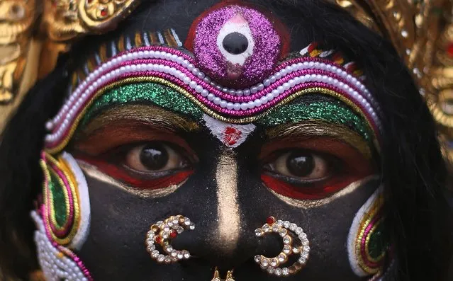 An Indian artist dressed as Hindu goddess Kali performs during a procession as part of “Bonalu” festivities in Hyderabad, India, Monday, July 21, 2014. Bonalu is a Hindu folk festival of the Telangana State. (Photo by Mahesh Kumar A./AP Photo)