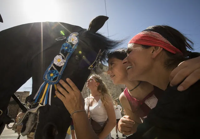 People look in a mirror on a horse's forehead during the traditional San Juan (Saint John) festival in the town of Ciutadella, on the Balearic Island of Minorca, on the eve of Saint John's day on June 23, 2022. (Photo by Jaime Reina/AFP Photo)