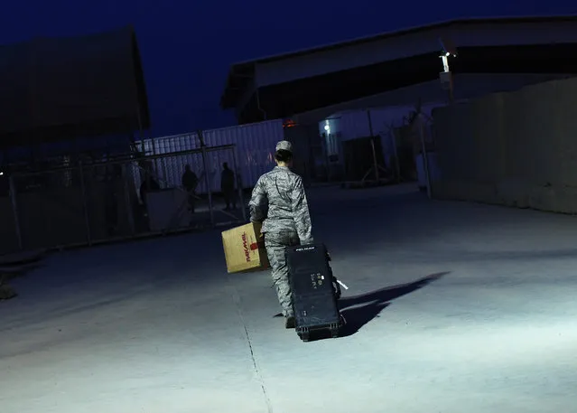 U.S. Air Force Major Stacie Shafran carries her luggage to a loading paddock while waiting for her departure from Iraq at the former U.S. Sather Air Base near Baghdad, Iraq, December 14, 2011. (Photo by Shannon Stapleton/Reuters)