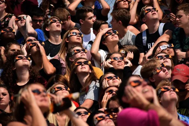 Students from Davison High School look at the solar eclipse Monday, August 21, 2017 from Cardinal Stadium in Davison, Mich. (Photo by Roberto Acosta/The Flint Journal-MLive.com via AP Photo)