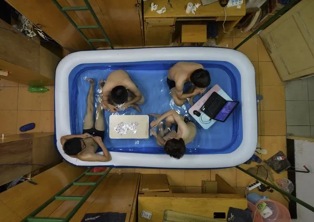 College students cool themselves inside an inflatable pool during the summer heat, at their dormitory in Wuhan, Hubei province, August 5, 2014. (Photo by Reuters/China Daily)