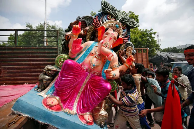 An idol of the Hindu god Ganesh, the deity of prosperity, is loaded onto a supply truck to be transported to a place of worship on the first day of the ten-day-long Ganesh Chaturthi festival in Ahmedabad, India August 25, 2017. (Photo by Amit Dave/Reuters)