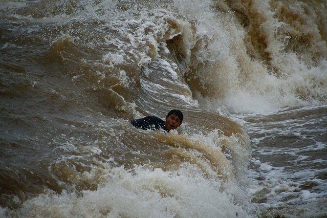 A man swims despite a storm warning as Tropical Storm John is on track to become a hurricane again, hurtling back towards communities across the Pacific coast, in Acapulco, Mexico on September 25, 2024. (Photo by Javier Verdin/Reuters)