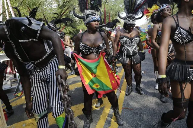 Dancers perform for spectators during the West Indian Day Parade, Monday, September 1, 2014 in the Brooklyn borough of New York. (Photo by Mark Lennihan/AP Photo)