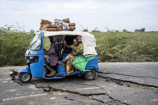 Residents ride a tuk-tuk taxi along a road damaged by multiple earthquakes near the town of Kabanna, on January 12, 2025. Evacuations and displacement are underway in Ethiopia after a series of earthquakes rocked the remote north of the Horn of Africa nation. The earthquakes have damaged houses and threatened to trigger a volcanic eruption of the previously dormant Mount Dofan, near Segento in the northeast Afar region. (Photo by Amanuel Sileshi/AFP Photo)