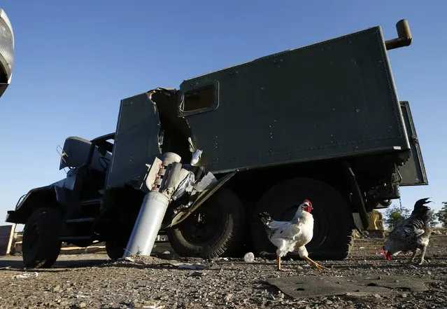 A Ukrainian military vehicle damaged by an unexploded rocket shell is seen at the site of recent shelling near the village of Dmytrivka in eastern Ukraine, September 19, 2014. (Photo by David Mdzinarishvili/Reuters)