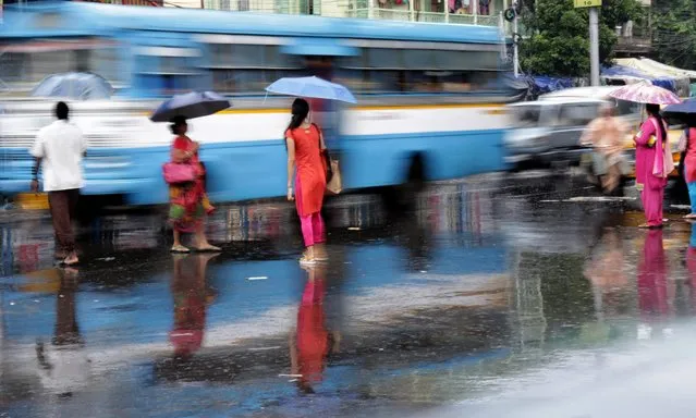 Indian commuters cross a street during monsoon showers in Calcutta, eastern India, 22 August 2016. A monsoon shower hit the city and disrupted daily life. The Indian monsoon season usually takes place between May and September. (Photo by Piyal Adhikary/EPA)
