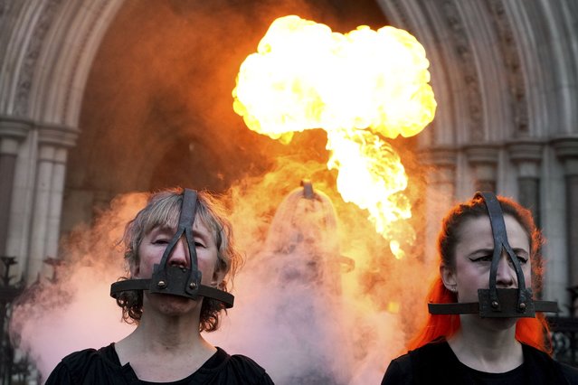 Climate activisits wear scold's bridles to highlight the silencing of those fighting for climate justice, outside The Royal Courts of Justice in London, Wednesday, January 29, 2025. (Photo by Kirsty Wigglesworth/AP Photo)