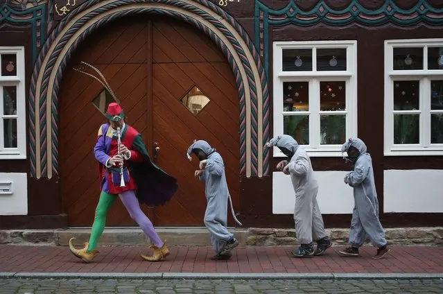 The Pied Piper of Hamelin, actually city tourism employee Michael Boyer, leads local children dressed as rats through a quiet street on November 19, 2012 in Hameln, Germany. The Pied Piper (in German: Der Rattenfaenger), is one of the many stories featured in the collection of fairy tales collected by the Grimm brothers, and the 200th anniversary of the first publication of the stories will take place this coming December 20th. Boyer, a U.S. citizen who has lived in Hameln for 15 years, and city children regularly perform a reenactment of the Pied Piper tale throughout the summer months. The Grimm brothers collected their stories from oral traditions in the region between Frankfurt and Bremen in the early 19th century, and the works include such global classics as Sleeping Beauty, Little Red Riding Hood, Rapunzel, Cinderella and Hansel and Gretel.  (Photo by Sean Gallup)
