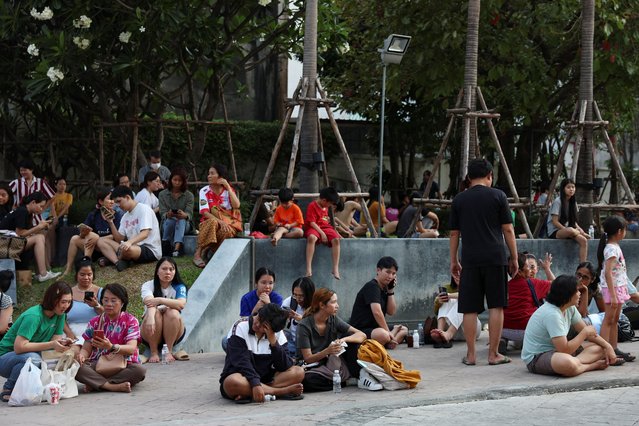 People sit on the pavement after a strong earthquake struck central Myanmar on Friday, earthquake monitoring services said, which affected Bangkok as well with hundreds of people pouring out of buildings in the Thai capital in panic after the tremors, in Bangkok, Thailand, on March 28, 2025. (Photo by Chalinee Thirasupa/Reuters)