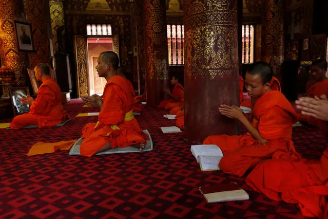 Monks attend an evening prayer at Wat Sene Buddhist temple in Luang Prabang, Laos July 30, 2016. (Photo by Jorge Silva/Reuters)