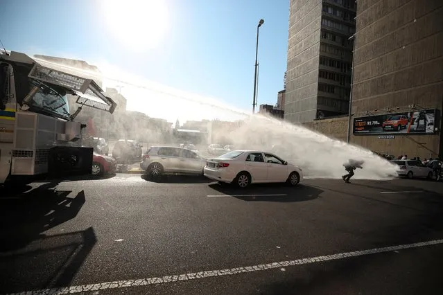 Police use a water canon to disperse restaurant workers protesting against coronavirus disease (COVID-19) lockdown regulations in Cape Town, South Africa, July 24, 2020. (Photo by Mike Hutchings/Reuters)