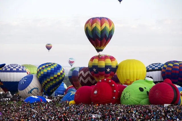 Hot air balloons lift off on the first day of the 2015 Albuquerque International Balloon Fiesta in Albuquerque, New Mexico, October 3, 2015. (Photo by Lucas Jackson/Reuters)