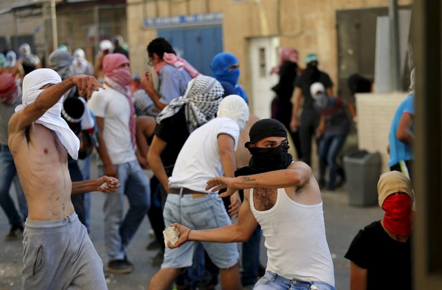 Palestinian protesters throw stones towards Israeli police (not seen) during clashes in Shuafat, an Arab suburb of Jerusalem October 5, 2015. (Photo by Ammar Awad/Reuters)