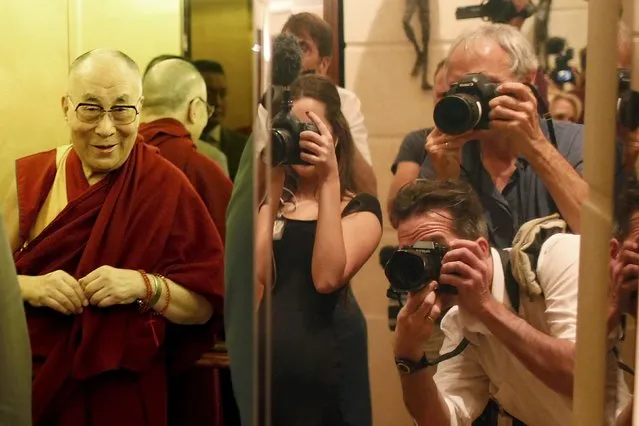 Tibet's exiled spiritual leader the Dalai Lama (L) stands in an elevator as news photographers are reflected in the door after a news conference in Paris, France, September 13, 2016. (Photo by Charles Platiau/Reuters)