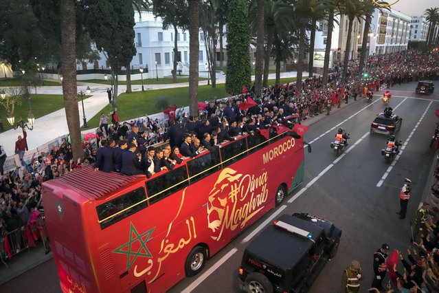 The players of Morocco national soccer team celebrate on a bus and wave during a homecoming parade in central Rabat, Morocco, Tuesday, December 20, 2022. Morocco national team won the fourth place at the last World Cup. (Photo by Mosa'ab Elshamy/AP Photo)