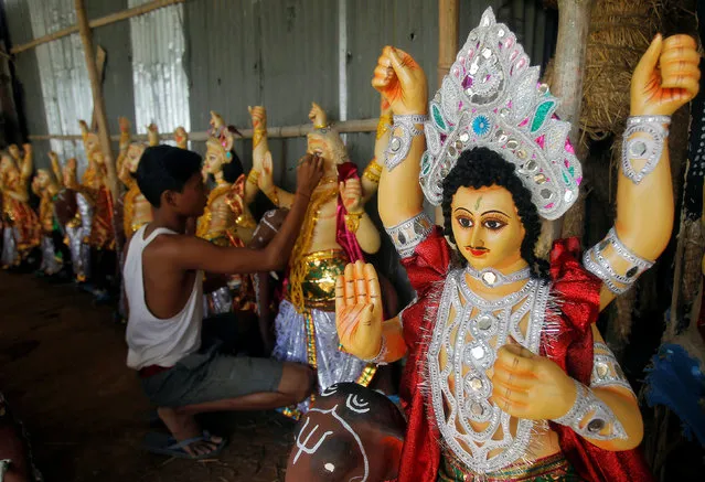 An artisan paints an idol of Lord Vishwakarma, the Hindu deity of architecture and machinery, inside a workshop ahead of the Vishwakarma festival in Agartala, India, September 15, 2016. (Photo by Jayanta Dey/Reuters)