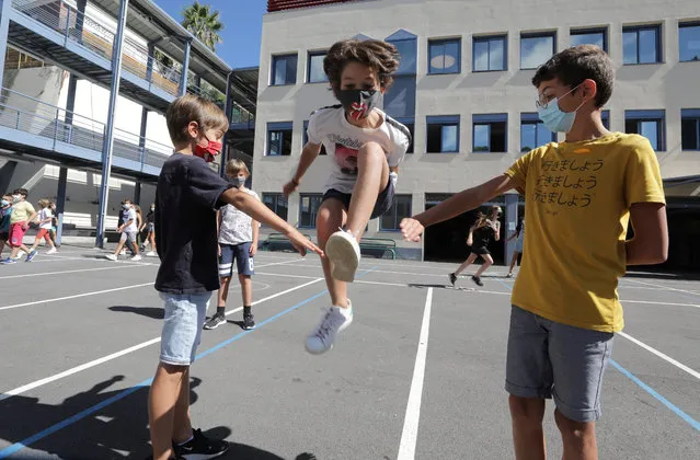 Secondary school students, wearing protective face masks, play in the courtyard at the College Henri Matisse school during its reopening in Nice as French children return to their schools after the summer break with protective face masks and social distancing as part of efforts to curb a resurgence of the coronavirus disease (COVID-19) across France, September 1, 2020. (Photo by Eric Gaillard/Reuters)