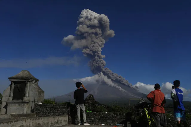 Mayon volcano spews ash as it erupts anew Tuesday, January 23, 2018 as seen from Legazpi city, Albay province, southeast of Manila, Philippines. The Philippines' most active volcano ejected a huge column of lava fragments, ash and smoke in another thunderous explosion at dawn Tuesday, sending thousands of villagers back to evacuation centers and prompting a warning that a violent eruption may be imminent. (Photo by Bullit Marquez/AP Photo)
