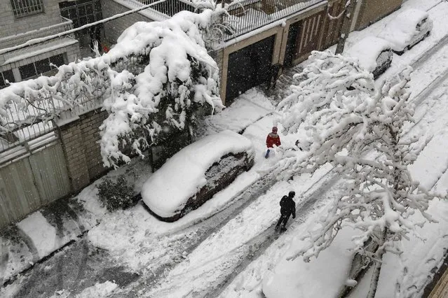 Iranians walk amid the snow in the capital Tehran on January 28, 2018. Some 20 provinces in the west and north of Iran were affected by the snowfall that began on Thursday and peaked on Saturday night, with some mountainous areas receiving as much 1.3 metres (more than four feet) of snow according to official news agency IRNA. (Photo by Atta Kenare/AFP Photo)