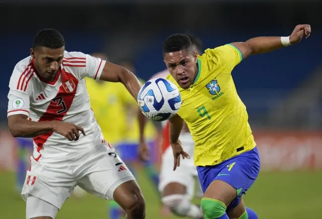 Peru's Jose Sanchez, left, and Brazil's Vitor Roque, battle for the ball during a South America U-20 Championship soccer match in Cali, Colombia, Thursday, January 19, 2023. (Photo by Fernando Vergara/AP Photo)