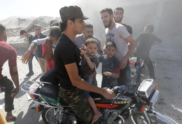 Men evacuate children who survived an airstirke in the rebel-controlled area of Maaret al-Numan town in Idlib province, Syria, September 25, 2016. (Photo by Khalil Ashawi/Reuters)