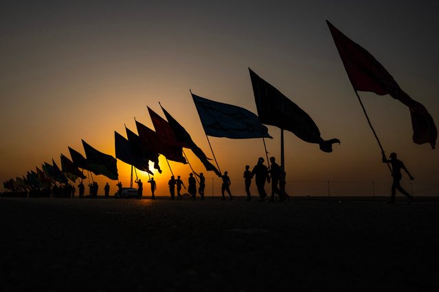 Iranian Shiite Muslims arrive on foot in Basra at sunset via the Shalamcheh border crossing, to take part in the Arbaeen pilgrimage in the Iraqi city of Karbala, on July 25, 2025. Each year, pilgrims converge in large numbers to the holy Iraqi cities of Najaf and Karbala ahead of Arbaeen, which marks the 40th day after Ashura, commemorating the seventh century killing of Prophet Mohammed's grandson Imam Hussein. (Photo by Hussein Faleh/AFP Photo)