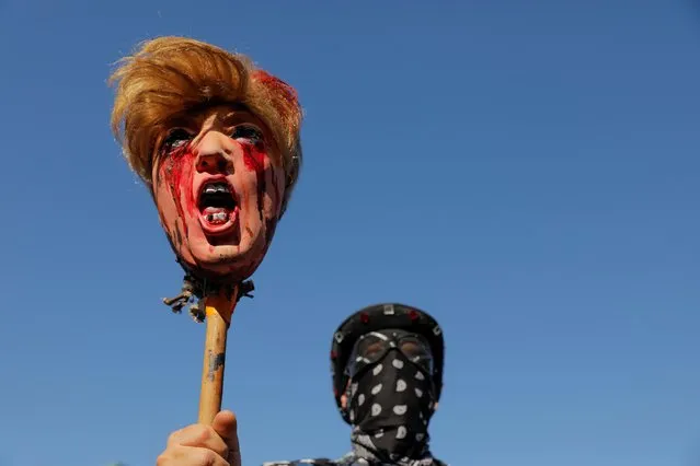 A person holding a figure depicting the head of U.S. President Donald Trump celebrates media announcing that Democratic U.S. presidential nominee Joe Biden has won the 2020 U.S. presidential election in the Alphabet City neighborhood of Manhattan, in New York City, U.S. November 7, 2020. (Photo by Andrew Kelly/Reuters)