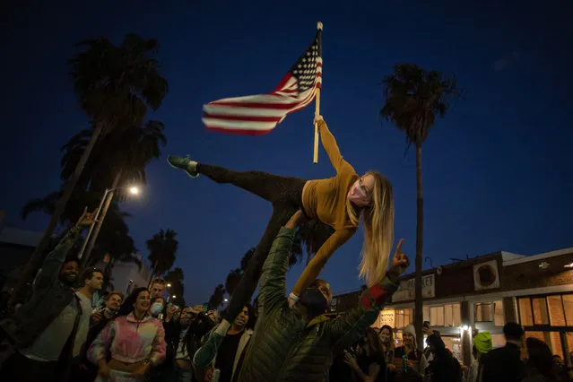 People dance in the Venice Beach neighborhood of Los Angeles, California as they celebrate after Joe Biden was declared winner of the 2020 presidential election on November 7, 2020. Democrat Joe Biden urged unity on November 7 and promised “a new day for America” in his first national address since he won the tense US election and ended the historically turbulent and divisive era of Donald Trump. (Photo by Apu Gomes/AFP Photo)