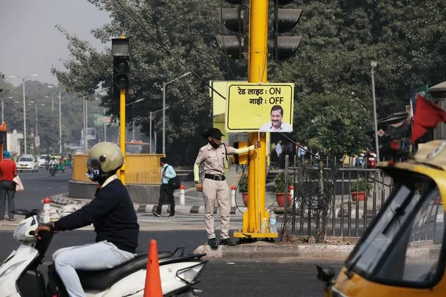 Rihana Saif (22), a member of Civil Defence, holds a placard instructing motorists to turn off their engines as a part of the Delhi government's traffic campaign to raise awareness about pollution, in New Delhi, India, November 12, 2020. Picture taken on November 12, 2020. (Photo by Anushree Fadnavis/Reuters)