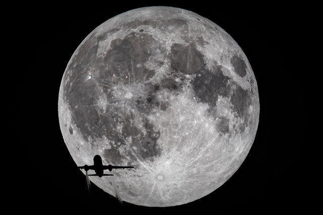 A British Airways flight from Marseille to London Heathrow crosses the full moon, 7th September 2025, seen from Croydon in South London. A lunar eclipse occurred today when the Earth came between the sun and the full moon, casting a shadow on the moon and giving it a reddish glow known as a blood moon. (Photo by Ian Schofied/London News Pictures)