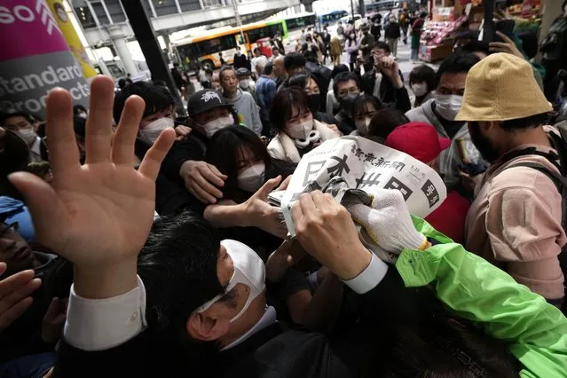 An employee distributes extra editions of the Yomiuri Shimbun newspaper reporting on Japan's victory at the final match of the World Baseball Classic Wednesday, March 22, 2023, in Tokyo. The headline of the newspaper said “Japan is No. 1 in the World”. (Photo by Eugene Hoshiko/AP Photo)