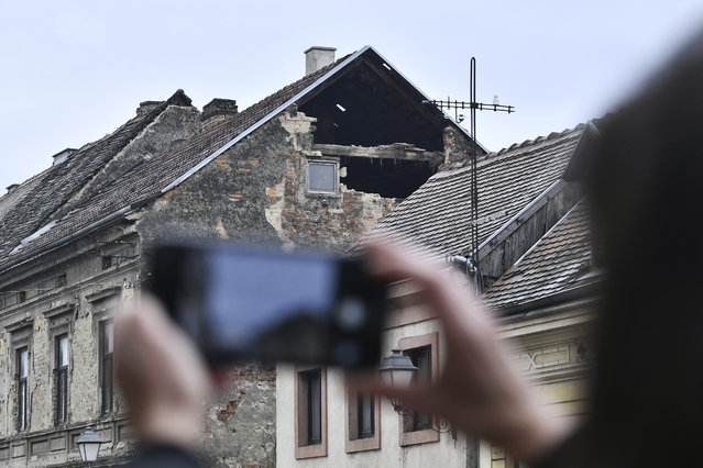 A resident takes a photograph of the damage caused by an earthquake in Sisak, Croatia, Monday, December 28, 2020. A moderate earthquake has hit central Croatia near its capital of Zagreb, triggering panic and some damage south of the city. There were no immediate reports of injuries. (Photo by AP Photo/Stringer)
