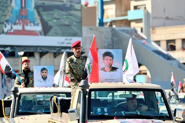Popular Mobilisation Forces march with posters and symbolic coffins of their killed fighters in Tahrir Square, Baghdad, Iraq, Saturday, December 26, 2020. (Photo by Khalid Mohammed/AP Photo)