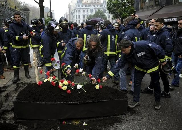 Firefighters take part in a protest in front of the regional parliament of Asturias to demand better organization and more staff in Oviedo, northern Spain, November 26, 2015. The protesters were simulating the burial of the Fire Department of Asturias. (Photo by Eloy Alonso/Reuters)