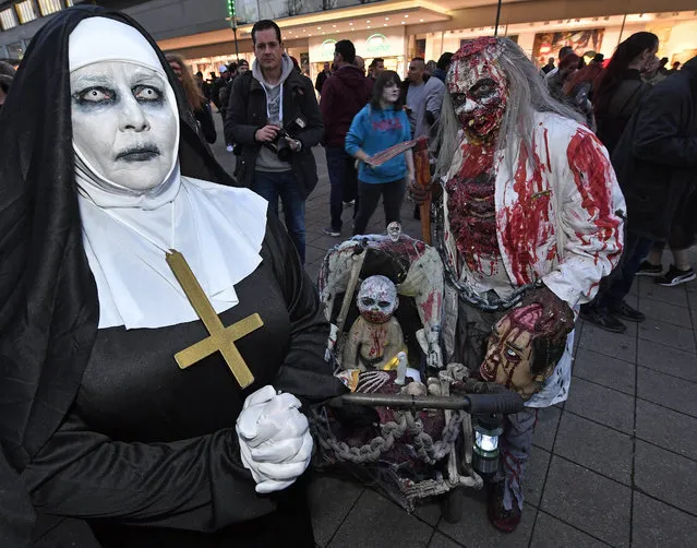 A couple dressed in Halloween costumes pose for a photo before participating in the zombie walk in Essen, Germany, Monday, October 31, 2016. Hundreds of young people celebrate Halloween at Germany's biggest horror walk through the city center of Essen. (Photo by Martin Meissner/AP Photo)