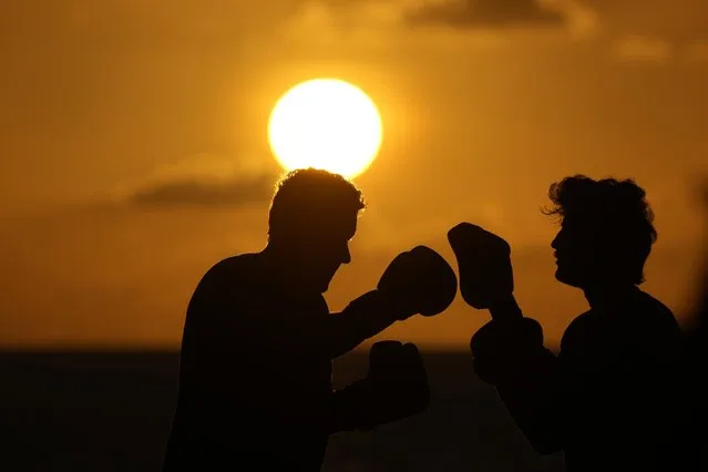 A pair of boxers train on the beach as the sun rises above the Atlantic Ocean, Tuesday, May 9, 2023, in Surfside, Fla. (Photo by Wilfredo Lee/AP Photo)