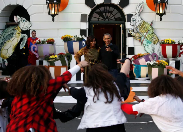 U.S. President Barack Obama and first lady Michelle Obama react to a flash mob of dancers portraying the zombies from Michael Jackson's Thriller video, after they finishing giving out Halloween treats to children from the South Portico of the White House in Washington, U.S. October 31, 2016. (Photo by Jonathan Ernst/Reuters)