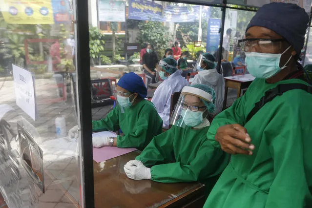 Health workers in a protective suit prepare for a coronavirus vaccine drill in Bali, Indonesia on Monday, January 11, 2021. Indonesia's highest Islamic body has gave its religious approval to China's Sinovac vaccine, paving the way for its distribution in the world's most populous Muslim nation. (Photo by Firdia Lisnawati/AP Photo)
