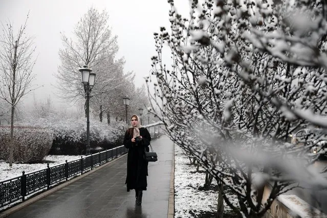A girl walks in a street after a snowfall in Grozny, Russia on January 12, 2021. This week temperatures are expected to fall as low as –9C. (Photo by Yelena Afonina/TASS)