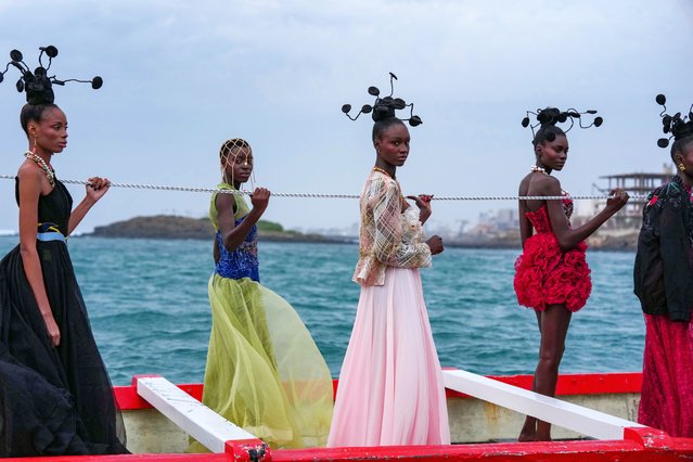 Models present creations in a traditional fishing boat during Dakar Fashion Week in Dakar, Senegal, Saturday, December 6, 2025. (Photo by Misper Apawu/AP Photo)