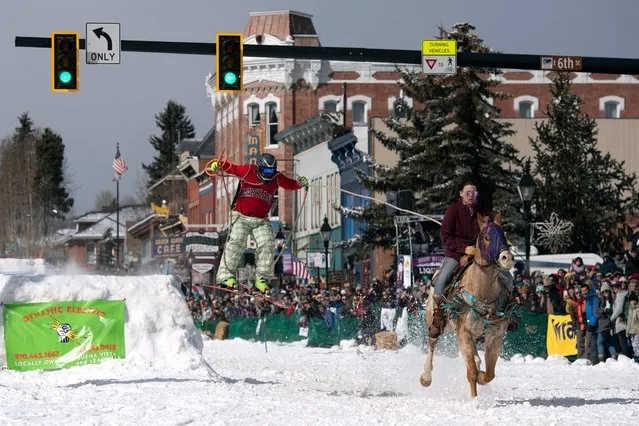 Rider Carissa Dahl (R) races down Harrison Avenue while skier Jason Decker airs out a jump during the 74th annual Leadville Ski Joring weekend competition on March 5, 2022 in Leadville, Colorado. Skijoring, which has its origins as a competitive sport in Scandinavia, has been adapted over the years to include a team made up of a rider and skier who must navigate jumps, slalom gates, and the spearing of rings for points. Leadville, with an elevation of 10,152 feet (3,094 m), the highest incorporated city in North America, has been hosting skijoring competitions since 1949. (Photo by Jason Connolly/AFP Photo)