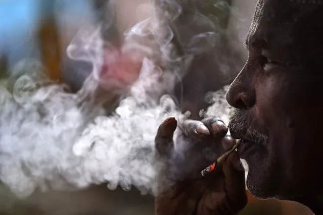 An Indian laborer smokes a beedi, a local cigarette wrapped with tobacco leaf, at a market area during World No Tobacco Day, in Chennai, India, 31 May 2023. World No Tobacco Day is marked annually on 31 May as an initiative by the World Health Organization (WHO) to raise awareness of the health risks of tobacco use and to push advocacy for policies to reduce tobacco consumption. This year's no tobacco global campaign's theme is “We need food, not tobacco”. (Photo by Idrees Mohammed/EPA/EFE)