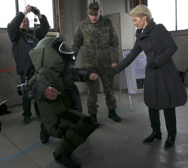 German Defence Minister Ursula von der Leyen is welcomed by a soldier in protective clothing during her visit at the German Armed Forces Bundeswehr training centre for warfare disposal in Stetten am kalten Markt, about 120 km (75 miles) south of Stuttgart January 19, 2015. (Photo by Michaela Rehle/Reuters)