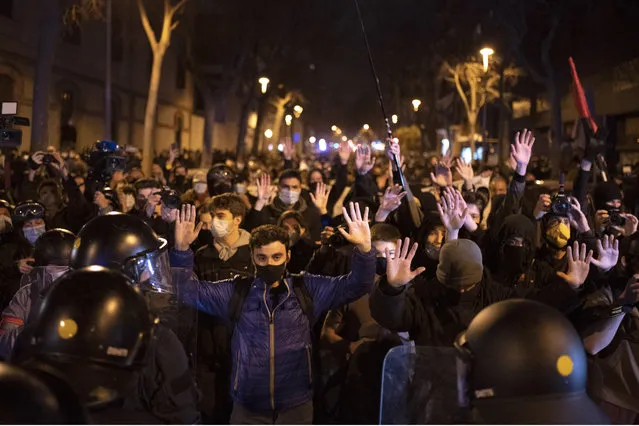 Demonstrators react as police cordon off the street during a march in Barcelona, Spain, Saturday, March 6, 2021. Several hundred protesters are marching in northeastern Spain's Barcelona against the crackdown that has followed the recent violent outcry over the imprisonment of Pablo Hasél, an outspoken anti-establishment artist and activist. (Photo by Emilio Morenatti/AP Photo)