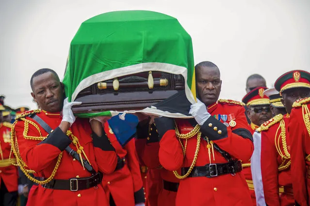 Military officers carry the coffin of former President John Magufuli, draped with the national flag, during a funeral service in his home town of Chato, Tanzania, Friday, March 26, 2021. Some thousands have gathered in the northwestern town of Chato for the burial of former Tanzanian President John Magufuli whose denial of COVID-19 brought the country international criticism. (Photo by AP Photo/Stringer)